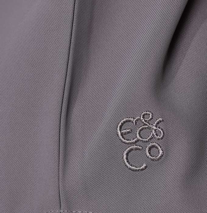 Close-up of a gray textured fabric with a small embroidered logo reading 'E&Co' in matching gray thread.